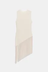 Top confeccionado en hilatura con mezcla de algodón, de cuello redondo y manga sisa, con detalle de aplicación de flecos combinados a tono y bajo asimétrico.