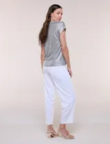 Blusa de tejido metalizado plateado con textura acanalada, escote en V y mangas corta con hombros caídos de calce fluido.