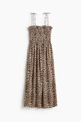 Vestido midi de viscosa con estampado animal print de leopardo, cuerpo fruncido con nido de abeja, escote recto, breteles finos ajustables con moñas y falda con vuelo.