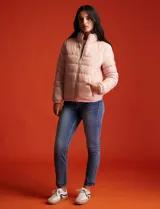 Campera de plumas reversible marca Michael Kors. Un lado es liso y el otro estampado con el logo de la marca. Tiene abertura central con cierre metálico, bolsillos delanteros y avíos metálicos con el logo. Incluye bolsa autoportante.