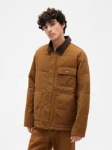 Campera acolchada de color marrón, con cierre frontal de botones a presión, cuello de pana en tono más oscuro y bolsillos frontales tipo parche.
