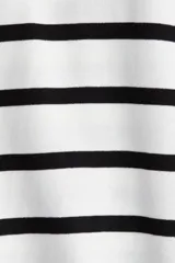 Remera de algodón con rayas horizontales negras sobre fondo blanco. Presenta cuello redondo acanalado negro y mangas cortas amplias.