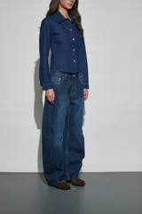 Jean de corte wide leg en color azul oscuro, con diseño de costuras laterales marcadas y tiro medio.