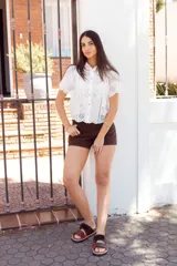 Sandalias de cuero color marrón con detalles en rojo, hechas a mano en Uruguay.