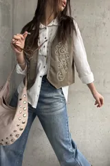Chaleco verde militar de gamuza, con bordados en hilo crudo, diseño de flores y detalles de tachas metálicas.