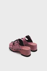 Sandalias de madera color rosa con plataforma y dos tiras de cuero rosa con hebillas negras.