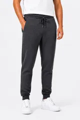Pantalón de jogging de felpa en color gris oscuro, con cintura elástica ajustable mediante cordón, bolsillos laterales y puños elásticos en los tobillos.