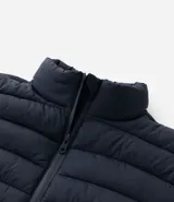 Campera puffer ultraligera de cuello alto con cierre frontal por cremallera y bolsillos laterales. Diseño acolchado con acabado liso.