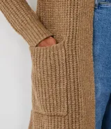 Cardigan largo de punto abierto, color marrón tostado, con mangas largas y dos bolsillos delanteros aplicados. Presenta una textura acanalada y diseño sin cierre.