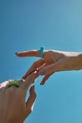 Set de dos anillos de resina, uno color verde con tres tachas doradas y otro color celeste.