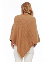Poncho tejido color crema, con cuello polera y diseño trenzado diagonal en el frente. Presenta un corte asimétrico en el ruedo.