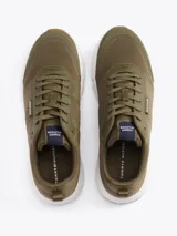 Zapatillas de running Tommy Hilfiger color verde oliva, con exterior de punto y poliéster, interior de poliéster, plantilla extraíble de goma termoplástica reciclada, suela de EVA dentada y trabilla para calzar.