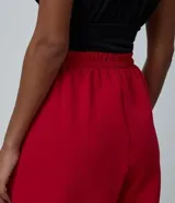 Pantalón de sastrería color rojo, modelo aladín con cintura alta, pinzas frontales y bajo ajustado. Confeccionado en tejido de viscosa con elastano.