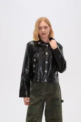 Chaqueta corta de eco-cuero negra con cuello camisero, cierre frontal con botones plateados y bolsillos simulados con botones plateados.