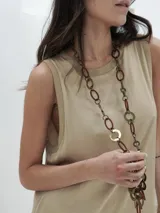 Vestido negro largo de tela satinada, sin mangas y con cuello redondo.