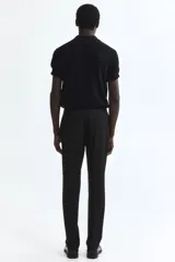 Pantalón tipo jogger de vestir, corte slim fit, con cintura elástica y cordón de ajuste. Presenta pliegues frontales y traseros, bolsillos laterales al bies y bolsillos traseros insertados.