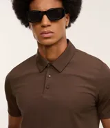 Camisa polo masculina de manga corta, confeccionada en tejido técnico de poliamida con elastano. Presenta cuello inglés con tapeta de tres botones, ofreciendo propiedades de secado rápido, elasticidad y confort térmico.