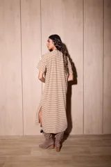 Vestido midi de algodón con diseño a rayas horizontales en color marrón y blanco. Presenta un corte holgado, cuello redondo, mangas cortas con hombros caídos y un pequeño bolsillo frontal en el pecho.