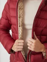 Campera puffer Michael Kors de color blanco, con diseño acolchado, cierre frontal metálico, bolsillos laterales con cierre y capucha desmontable. Incluye bolsa autoportante para guardado.