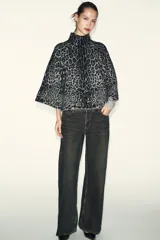 Jersey de punto con estampado animal jacquard en tonos gris y negro, caracterizado por su cuello subido y mangas anchas de corte holgado.