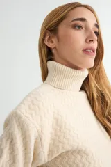 Polera de tejido de punto con cuello alto y textura acanalada en zigzag. Presenta mangas largas y puños ajustados, con un diseño clásico y versátil.