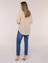 Camisa de rayas finas verticales en tonos amarillo y blanco, de corte clásico y silueta holgada. Cuenta con cuello camisero, cartera frontal de botones, un bolsillo plaqué en el pecho con rayas horizontales a contraste, mangas largas con presilla y ruedo curvo.