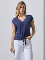 Blusa color beige de modal con escote en V, abertura central con botones y ruedo anudado. Marca French Laundry.