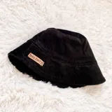 Gorro tipo bucket negro de pana con etiqueta rectangular con la marca "Valente".