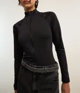 Blusa negra de microfibra con cuello alto y cierre frontal con cremallera, de manga larga y corte ajustado.