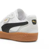 Championes Puma modelo Palermo, con diseño retro de perfil bajo. Presentan una combinación de cuero blanco y gamuza en tonos claros, con detalles en rosa pálido y una suela de goma color caramelo. Incluyen el logo de la marca en dorado en el lateral.