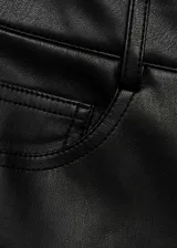 Pantalon de tiro alto con efecto piel, diseño recto y corte crop. Cuenta con cierre de cremallera y botón, trabillas para cinturón y cinco bolsillos.