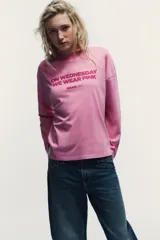 Camiseta de manga larga en color rosado con cuello redondo. Presenta un estampado frontal con la frase 'On Wednesday we wear pink' y el logo de Mean Girls en color fucsia.