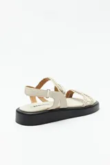 Sandalias color marrón con tiras trenzadas y ajuste de velcro en el talón. Plataforma de 3cm de alto y suela negra.