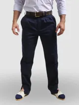 Pantalón de vestir azul marino, de corte recto, con bolsillos laterales y traseros. Se ajusta a la cintura con cinturón de cuero marrón.