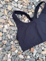 Top deportivo negro con espalda tipo nadadora y breteles anchos.