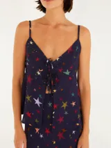 Top azul marino con estampado de estrellas de colores, tirantes finos regulables y escote en V con detalle de lazo en el busto.