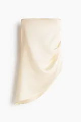 Top strapless de satén color beige, con diseño ceñido, drapeado lateral en la cintura y bajo asimétrico.