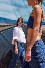 Jean de tiro bajo y corte oversize, confeccionado en denim azul con grabado láser de monograma en patrón de rombos. Presenta avíos metálicos y diseño de pierna ancha.