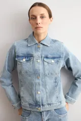 Chaqueta clásica de jean color celeste, con bolsillos frontales con solapa, cierre de botones metálicos y cuello camisero.
