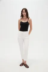 Pantalón jean de tiro alto y corte recto, color blanco, con bolsillos laterales y traseros, y terminación desmechada en los tobillos.