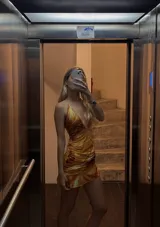 Vestido corto con estampado abstracto en tonos naranja, blanco y marrón. Diseño con escote halter y espalda descubierta.