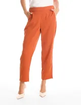 Pantalon de corte relajado color beige, con cintura plana en el frente y elástica en la parte posterior. Presenta pierna de corte recto, bolsillos laterales diagonales y bolsillos traseros simulados.