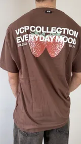 Remera blanca de corte regular, con estampa en la espalda que presenta la leyenda "VCP COLLECTION EVERYDAY MOOD" junto a un gráfico de fresas.