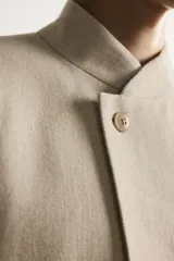Blazer de corte relaxed fit confeccionado en tejido de lino y algodón de origen italiano. Presenta cuello mao, cierre cruzado con botones, bolsillos de vivo en la cadera y manga larga.