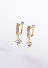Par de aros colgantes con cierre inglés, elaborados en plata 925 con baño de oro de 18k. Presentan un diseño de argolla pavé adornada con circonias cúbicas y un dije colgante de piedra zirconia en corte redondo.