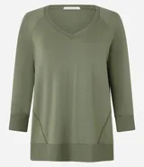 Blusa básica de viscosa verde militar con escote en V, mangas 3/4 y puños anchos en rib. Cuenta con costuras decorativas y dobladillo inferior ancho.