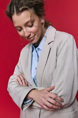 Blazer beige de corte recto, con solapa clásica, bolsillos frontales con solapa y cierre de un botón.
