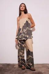 Top strapless color beige con estampado de hojas negras.