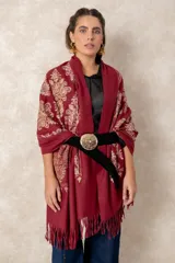 Pashmina de tela densa y suave en color bordó, con patrones bordados detallados en hilo dorado y beige, y terminación en flecos.