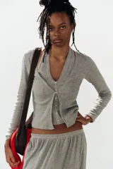 Top de punto efecto doble color gris melange, con diseño de cuello en pico, tirantes tipo halter interiores y cierre frontal con botones. Cuenta con mangas largas.